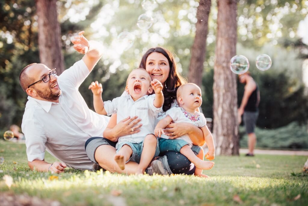 Happy family with children playing outdoors in a park in the US