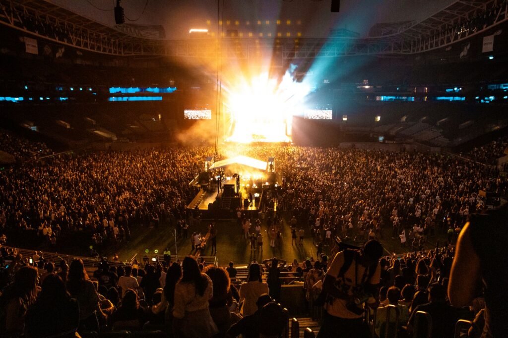 Concert crowd and stage lights at a stadium tour