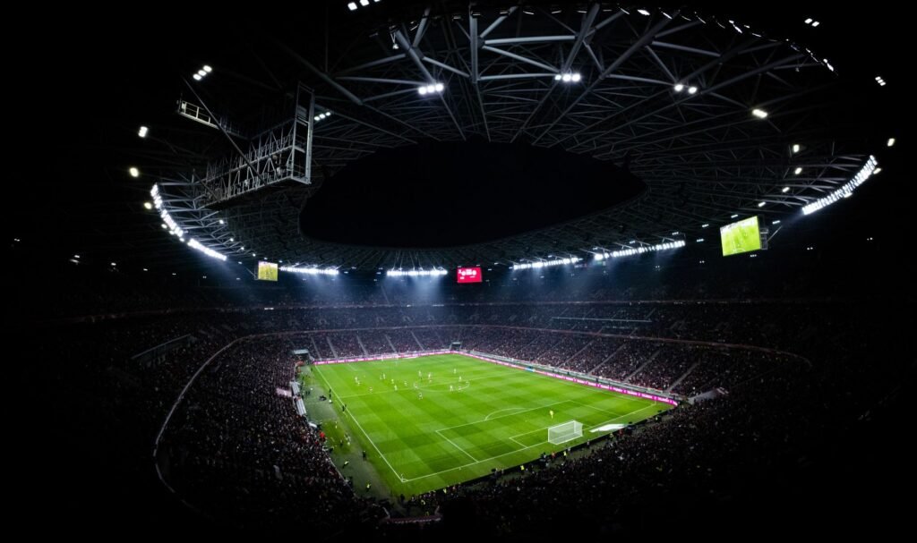 Football stadium under floodlights during a night match