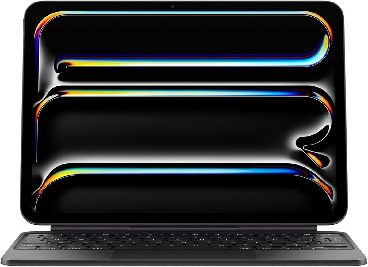 Apple Magic Keyboard holding an 11-inch iPad Pro above its glass trackpad and backlit keys