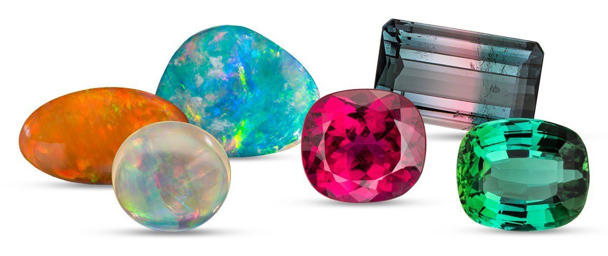 Three opals showing play-of-color beside pink, bicolor and green tourmalines