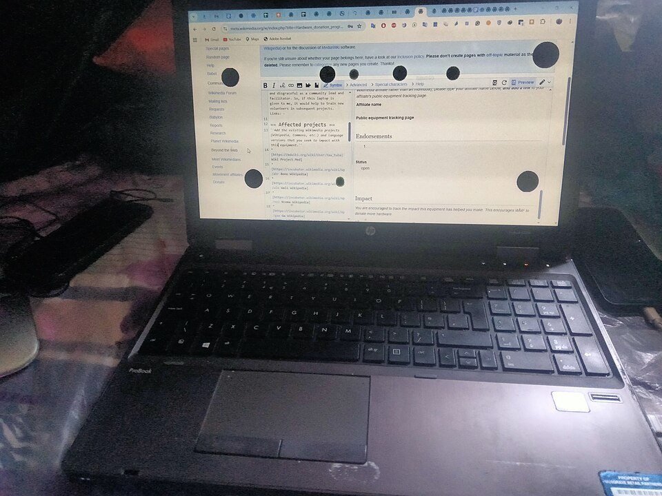 HP laptop with several round black spots scattered across a white web page on its LCD screen