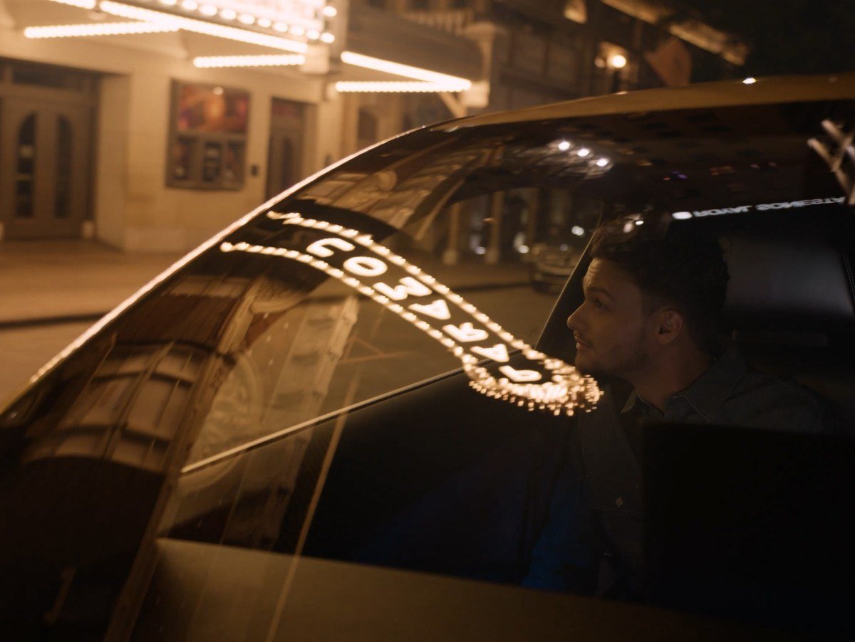 Passenger seated in a Tesla Robotaxi at night on a city street