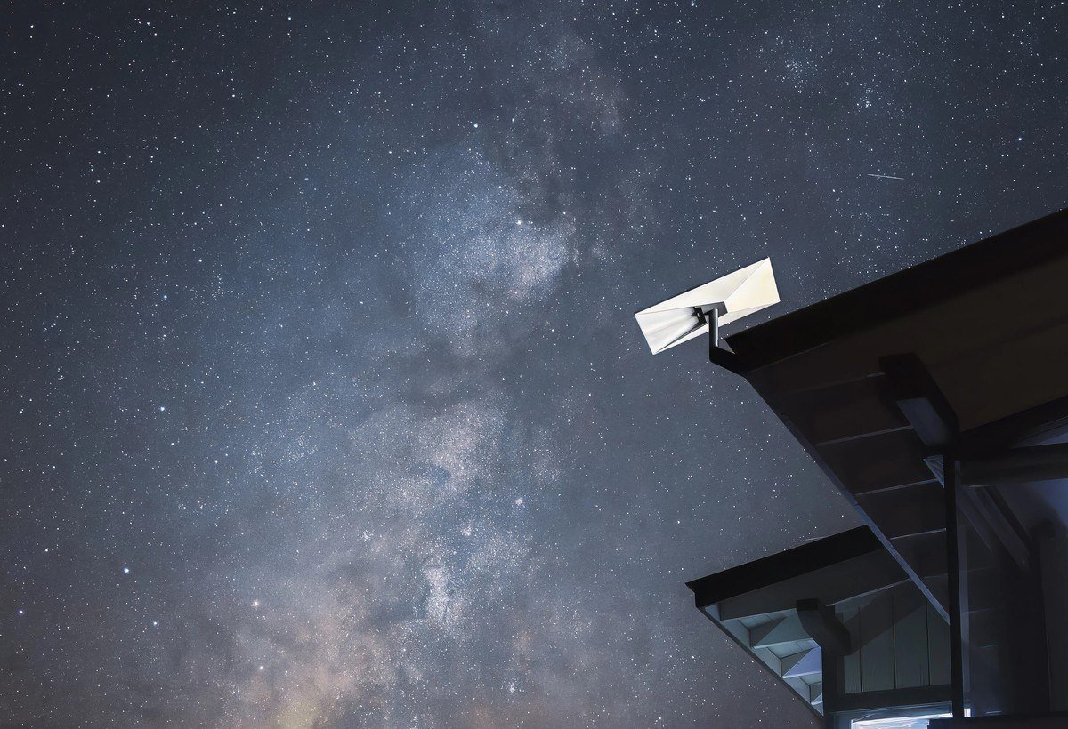 Starlink dish mounted on a roof edge under the Milky Way