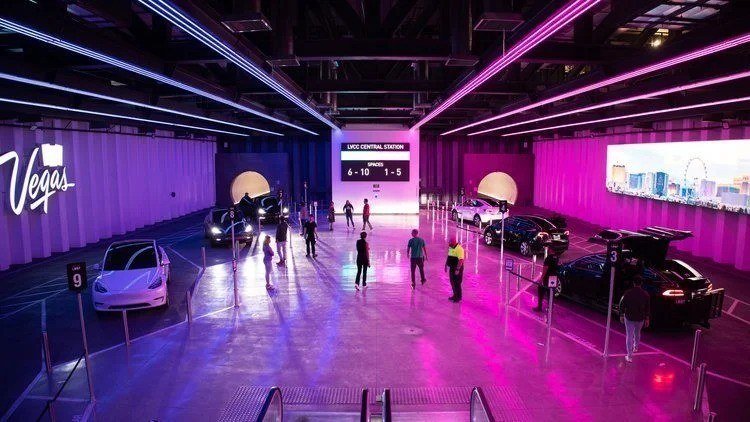 Vegas Loop station with Tesla cars parked under pink and purple lights
