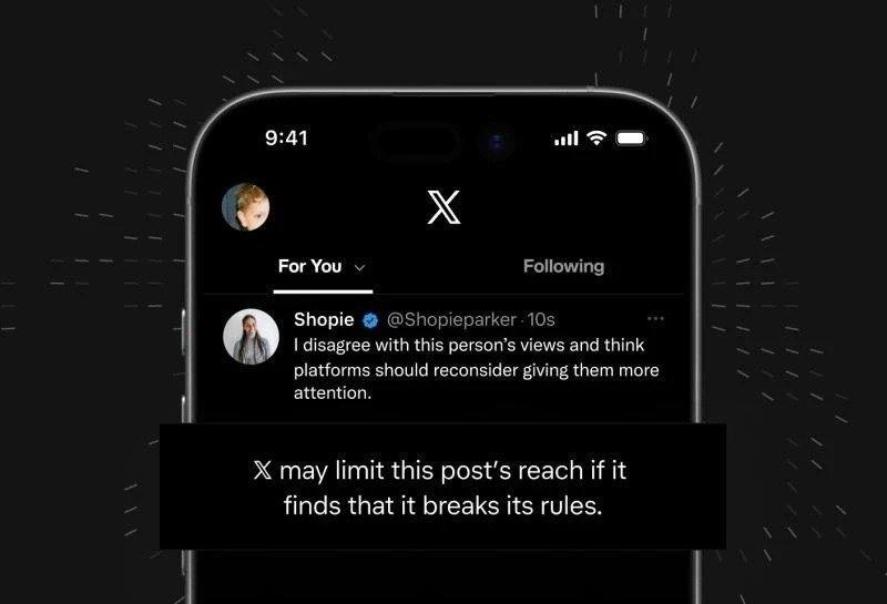 Phone showing the X feed with a notice that a post's reach may be limited