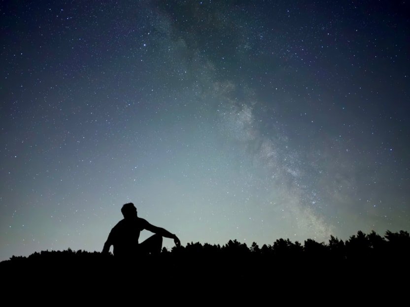 Night mode photograph on iPhone 18 Pro of a person silhouetted against a starry sky