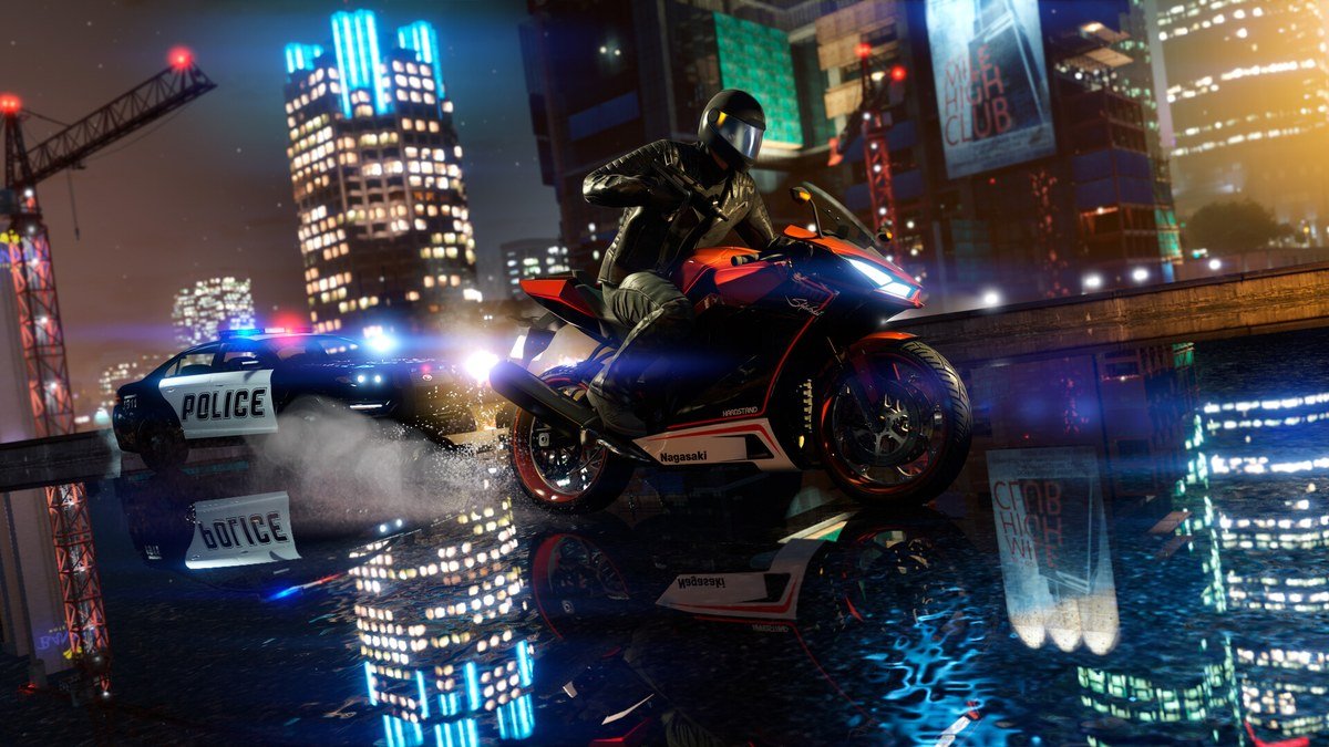 Police cruiser chasing a motorbike rider through neon-lit Los Santos at night in GTA 5