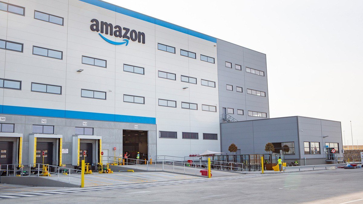 Exterior of an Amazon fulfillment center with the Amazon logo above loading docks