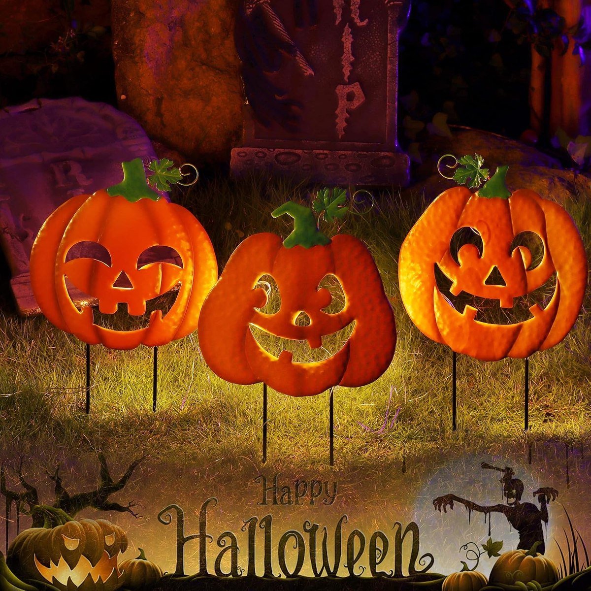 Three Juegoal metal jack-o-lantern yard stakes glowing on a lawn at night