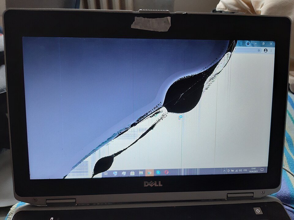 Dell laptop with a cracked LCD panel, dark ink spreading from the crack and vertical lines down the right side