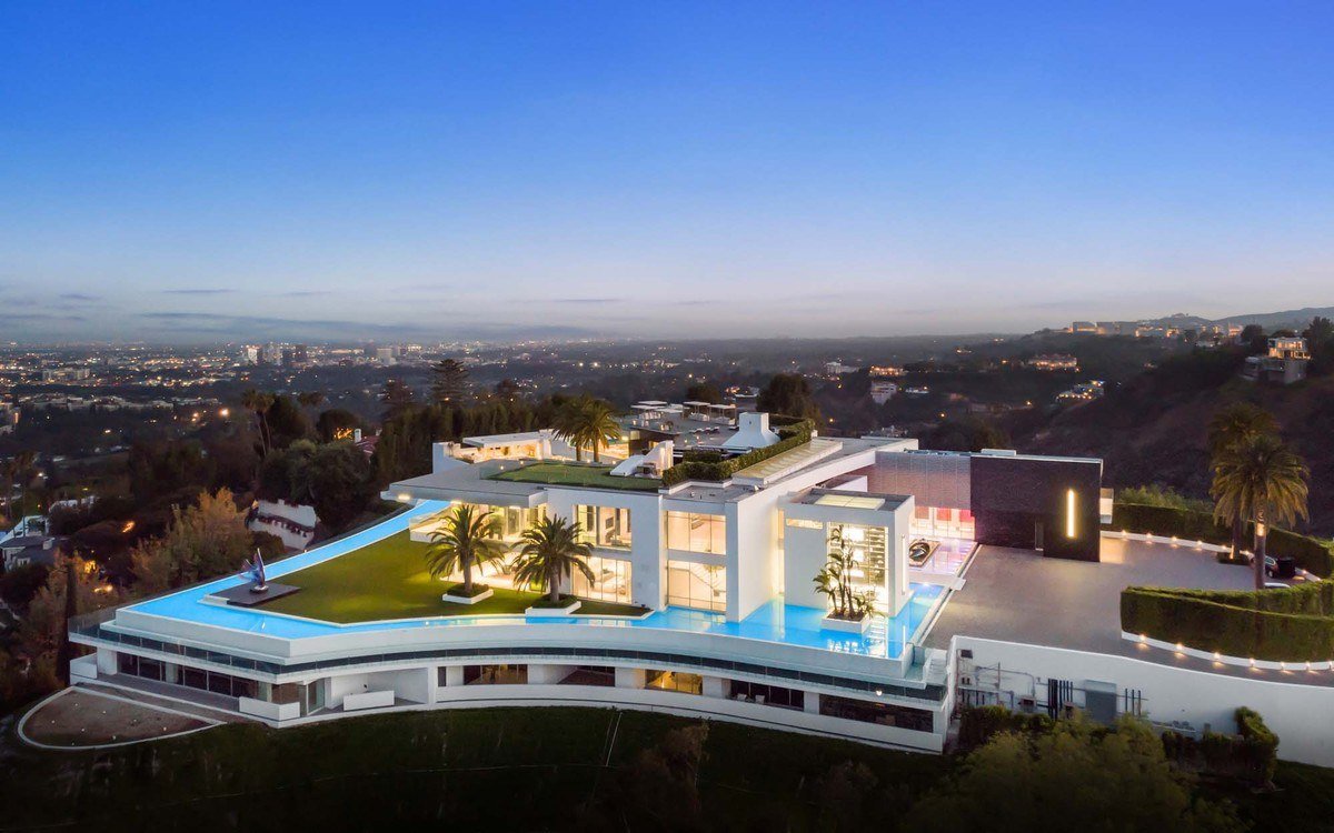 Aerial view at dusk of The One mansion on its Bel Air hilltop with the city beyond