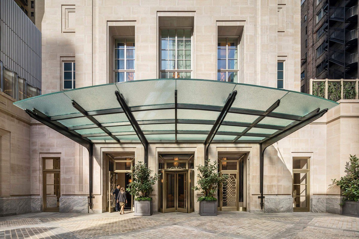 The glass entrance canopy and limestone facade of the villa at 220 Central Park South