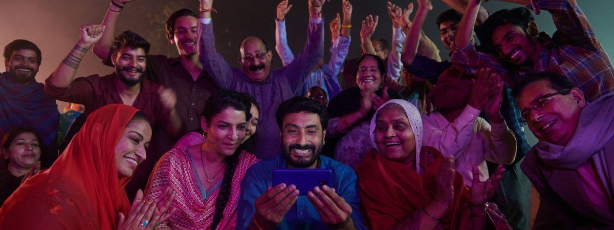 Group of smiling Jio customers and staff crowding into the frame