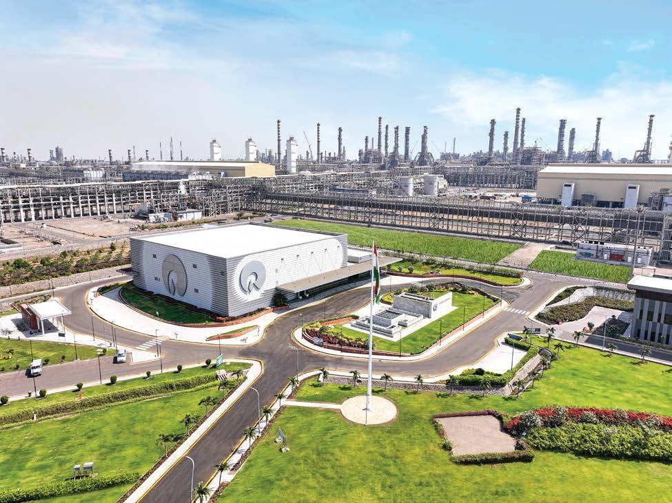 Aerial view of a Reliance refining and petrochemicals complex with a white administrative building in the foreground