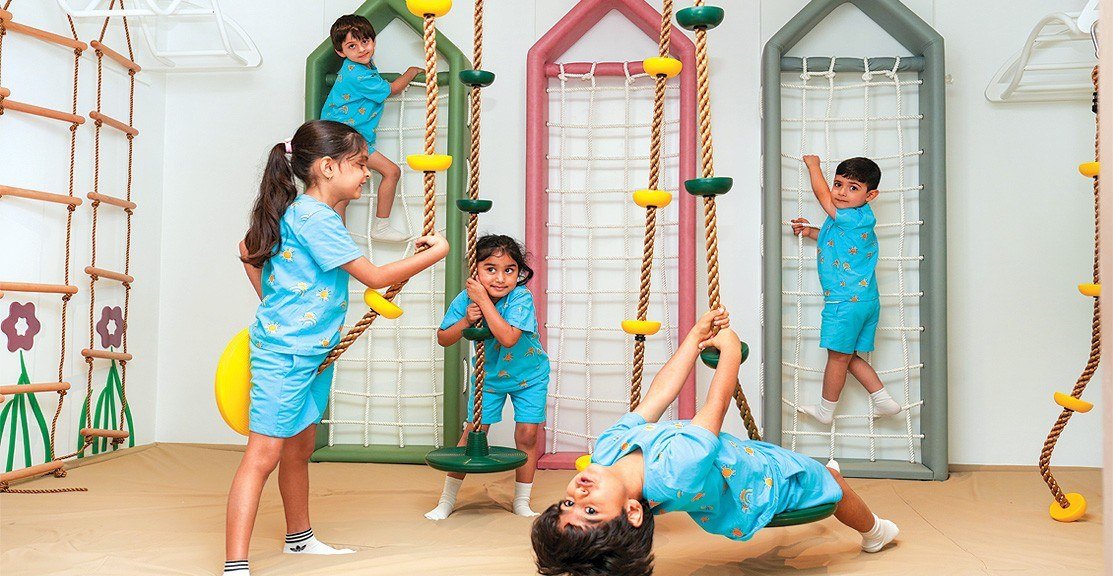 Children climbing and balancing on colourful play frames in a Reliance Foundation programme