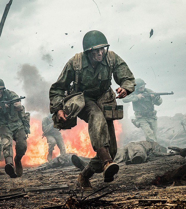 A soldier running through smoke and fire in a still from Hacksaw Ridge, directed by Mel Gibson