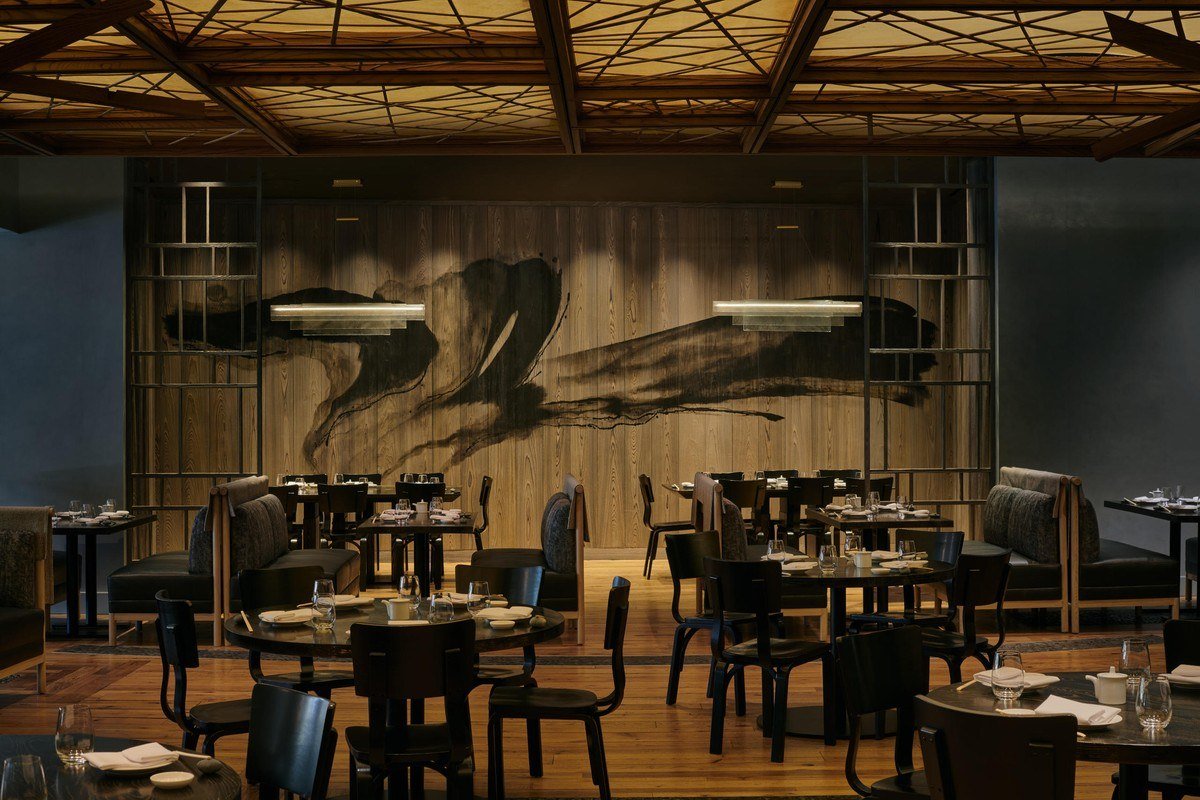 Dining room of Nobu Las Vegas with a dark wood ceiling and a large brush-stroke wall mural