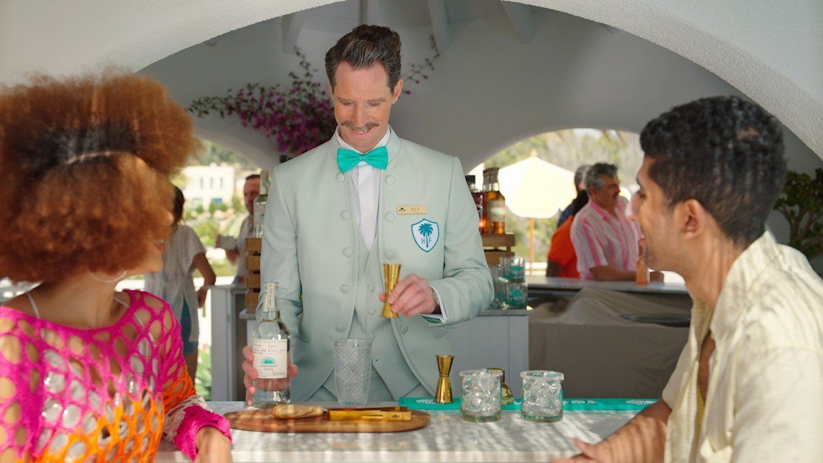 Guests and a server at a tequila bar counter, from the Casamigos website