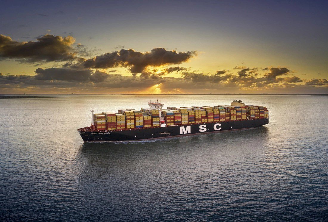 MSC container ship at sea under a sunset sky