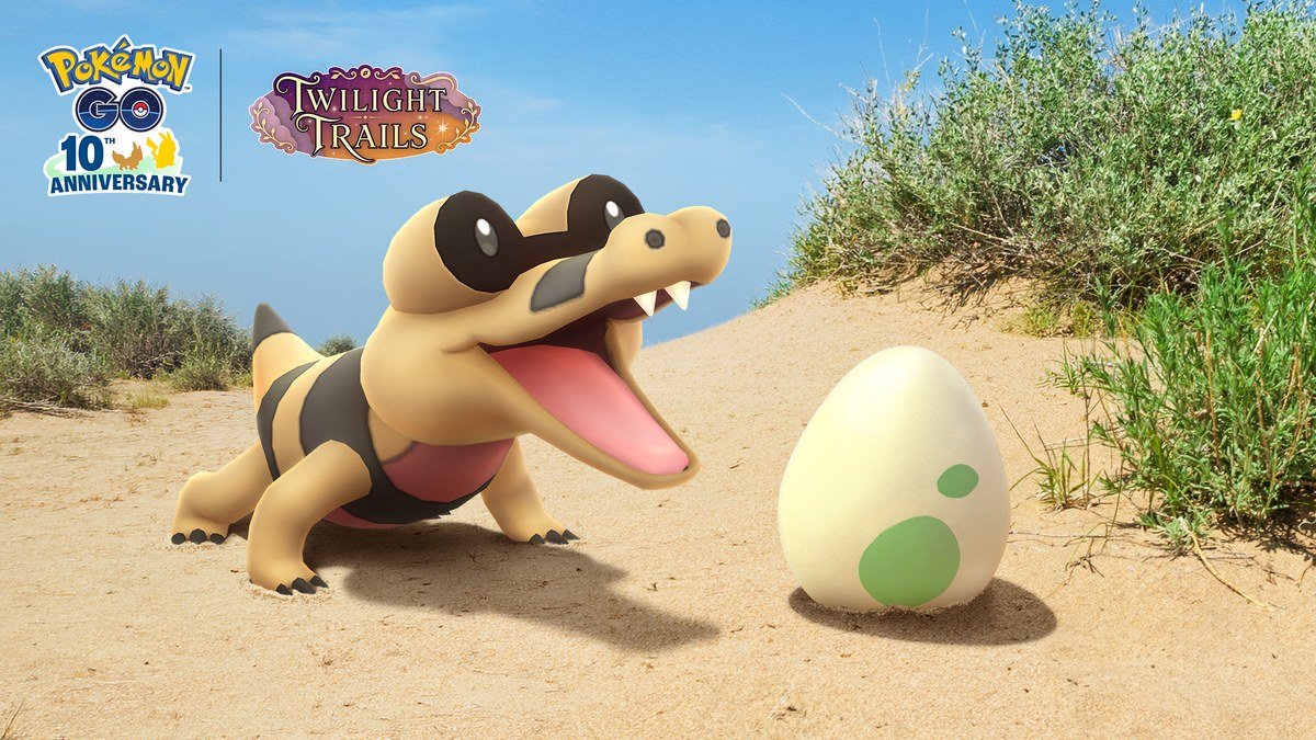 Sandile next to a 2 km Egg on a sandy beach for Pokémon GO Sandile Hatch Day