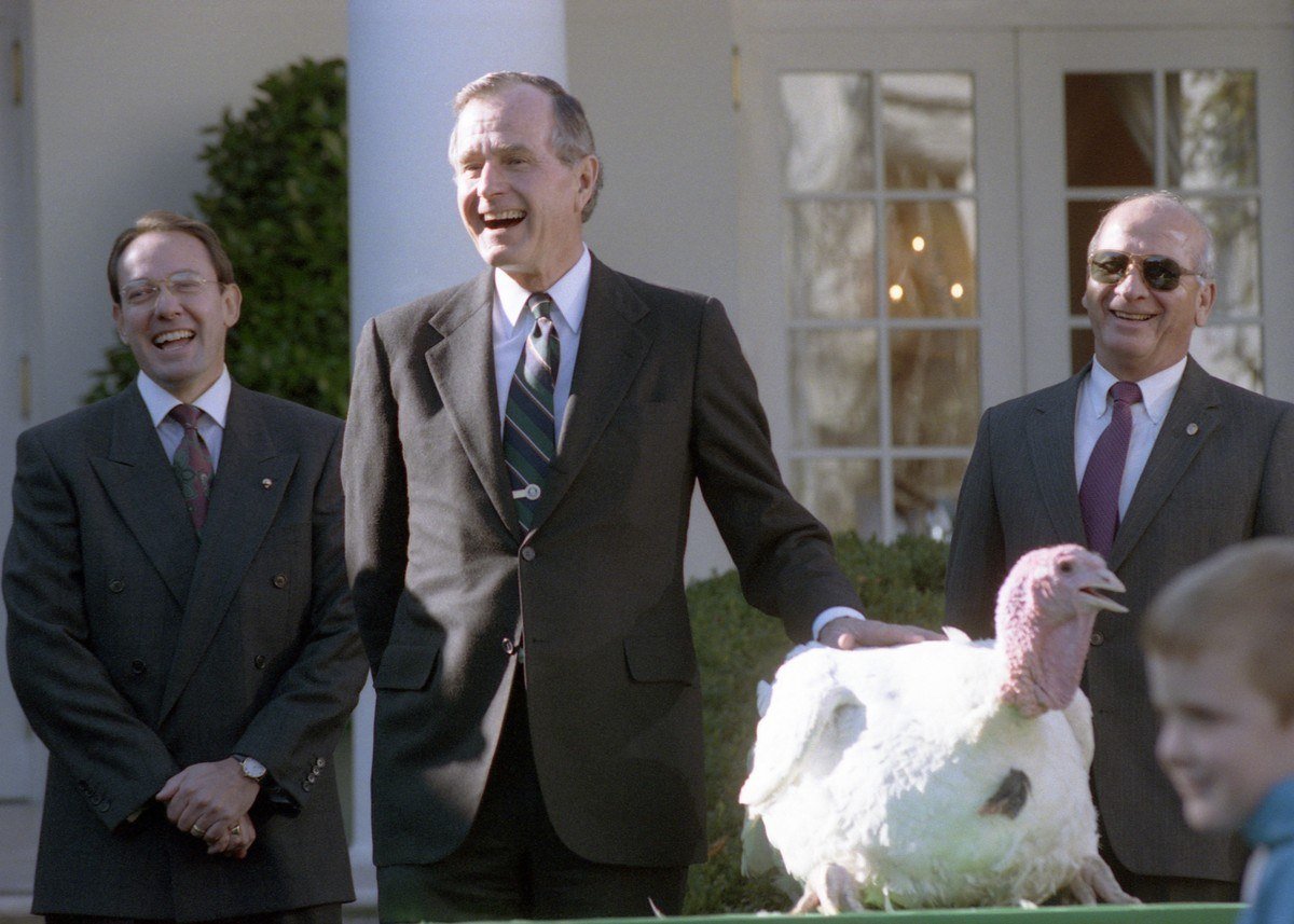 President George H.W. Bush laughing beside the National Thanksgiving Turkey in the White House Rose Garden in 1990